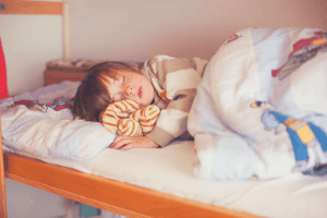 adorable boy sleeping in a bunk bed