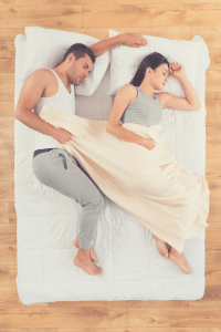 couple sleeping on a mattress on the floor