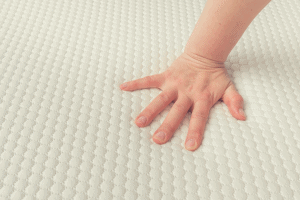 woman feeling the firmness of a mattress Topper