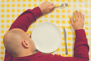 man sleeping while starving