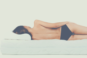 topless woman lying on a mattress without sheets