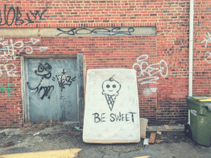 old mattress left in a dumpster